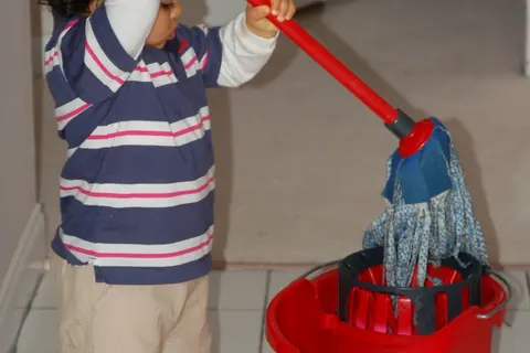 Person using a mop and bucket